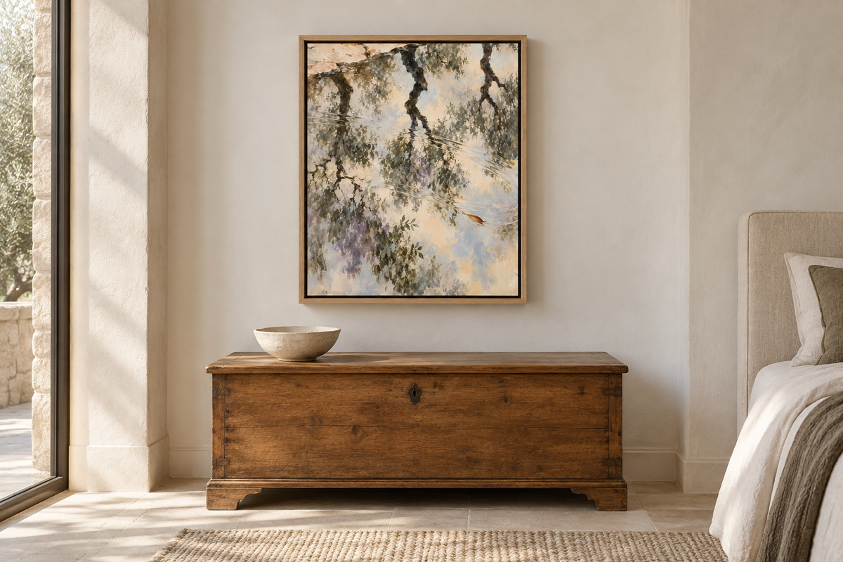 Olive Orchard After Rain in a Natural float frame above a wooden chest beside a linen bed. Room scale: 40.6 × 50.8 cm artwork (16 × 20 in). A styled room visualisation; furnishings not included.